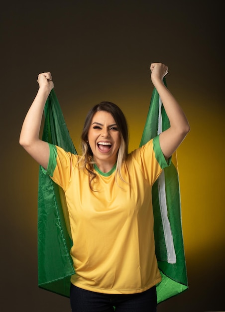 Brazilian fan Brazilian woman fan celebrating in soccer or soccer match on yellow background Brazil colors