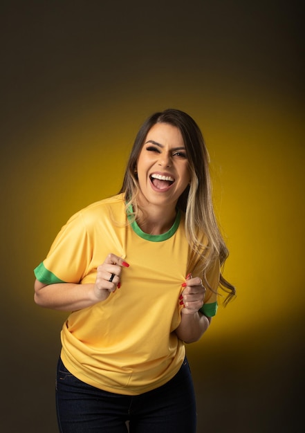 Brazilian fan Brazilian woman fan celebrating in soccer or soccer match on yellow background Brazil colors