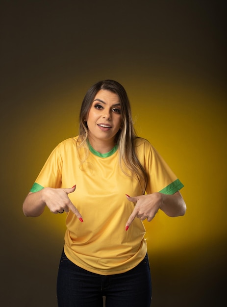 Brazilian fan Brazilian woman fan celebrating in soccer or soccer match on yellow background Brazil colors