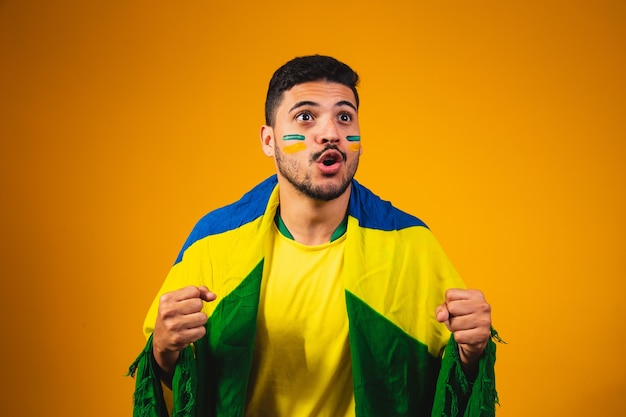 Fan brasiliano che acclamava tra la folla su sfondo giallo.