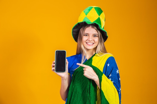 Brazilian fan holding a smartphone  with copy space