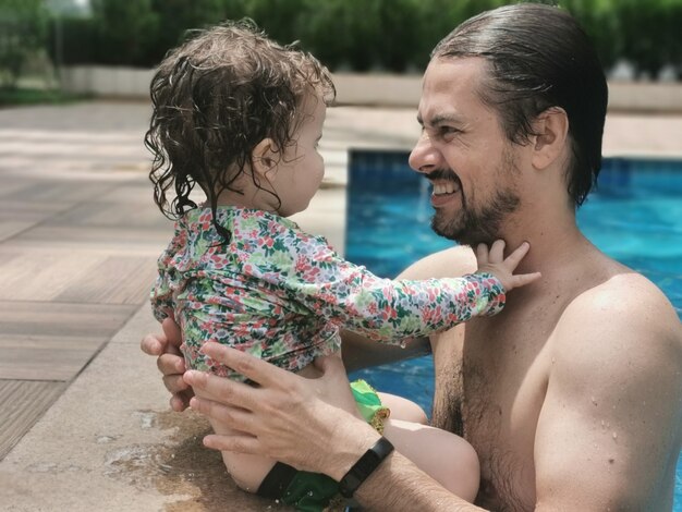 Brazilian Father and Daughter having fun at swimming pool.