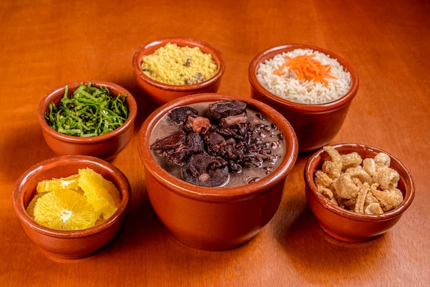 Feijoada brasiliana cibo a base di carne di maiale e salsiccia di fagioli neri con contorni tradizionali