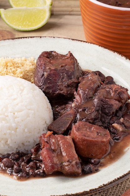 Brazilian feijoada served with rice and toasted manioc flour