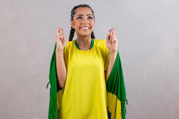 Brazilian female cheerleader with fingers crossed wishing luck