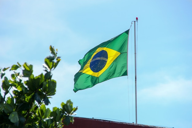 Бразильский флаг развевается под открытым небом в Рио-де-Жанейро, Бразилия.