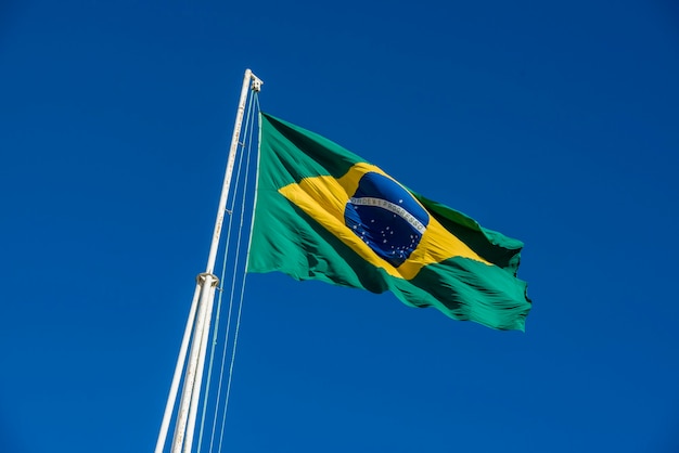 Brazilian flag hoisted with blue sky