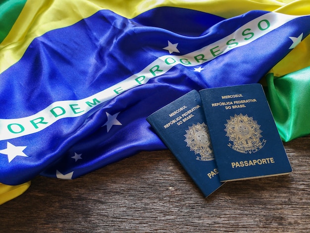 Brazilian flag with Brazilian passport and wooden table