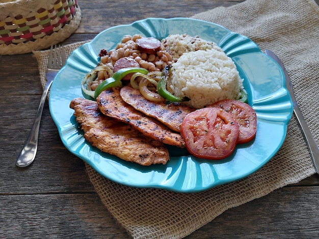 Бразильское блюдо Бобы, рис, курица-гриль и мука.