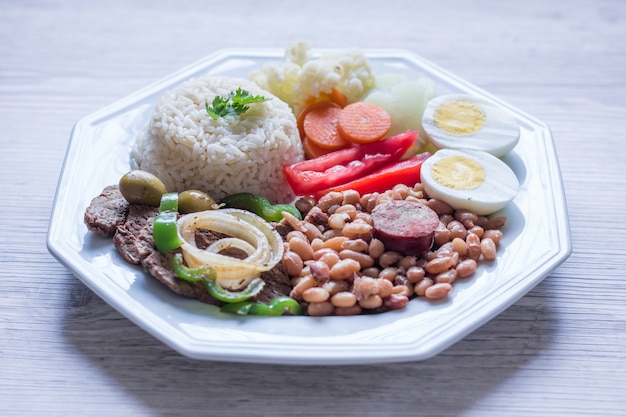 Brazilian food dish Beans, rice, meat, eggs, salad.