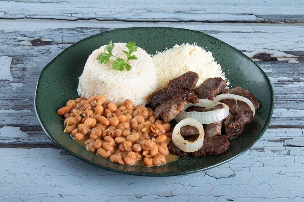 Brazilian food dish with beans rice and meat