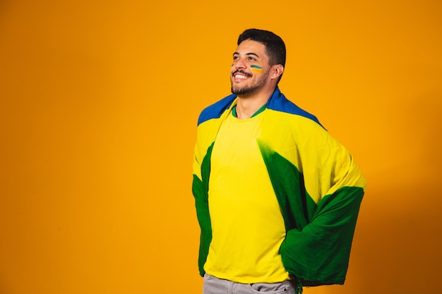 Brazilian football fan emotions: celebrating, excited, happy. Supporter of Brazil national soccer team is cheering.