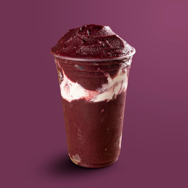 Бразильское замороженное мороженое AÃ§ai Berry Smoothie в пластиковой чашке со сгущенным молоком. изолированные на фиолетовом фоне. Вид спереди для меню и социальных сетей