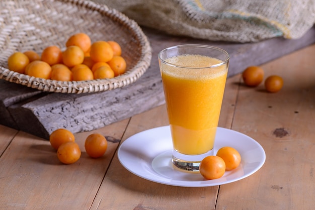 Caja di frutta brasiliana. bicchiere di succo sul tavolo di legno.