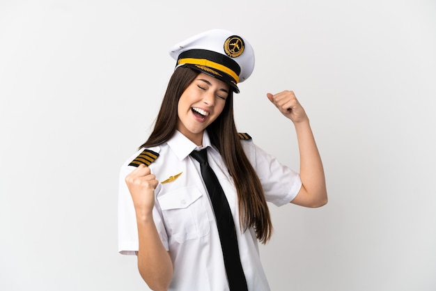 Brazilian girl Airplane pilot over isolated white background celebrating a victory