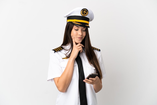 Brazilian girl Airplane pilot over isolated white background thinking and sending a message