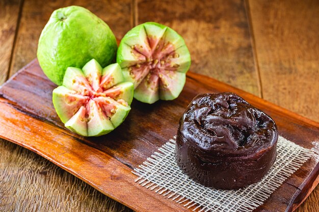 Photo brazilian guava jam, called marmalade or guava paste, with fruits in the background