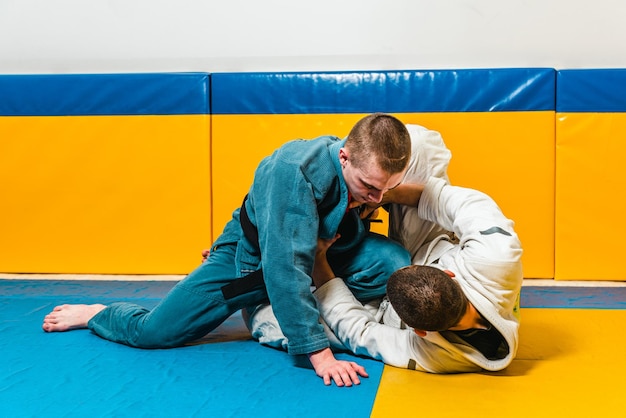 Foto allenamento di jiujitsu brasiliano e grappling per uomini in una palestra di autodifesa