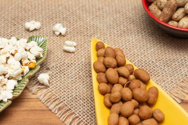 Brazilian june party snacks like popcorn peanuts and corn on straw background