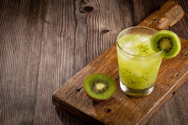 木製の背景にキウイとブラジルのキウイ カイピリーニャ Cachaca ドリンク
