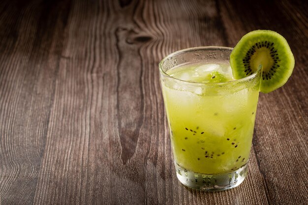 Brazilian Kiwi Caipirinha Cachaca drink with kiwi on wooden background