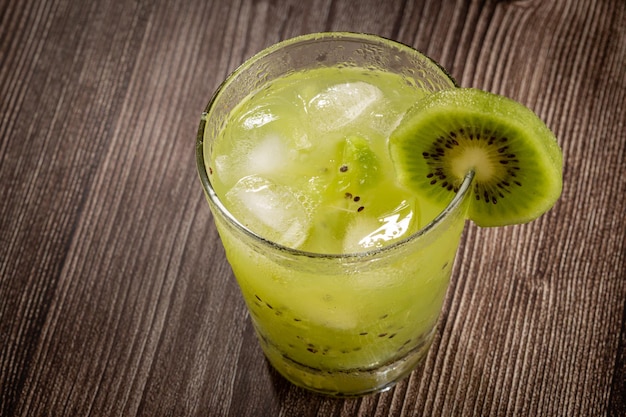 Brazilian Kiwi Caipirinha Cachaca drink with kiwi on wooden background