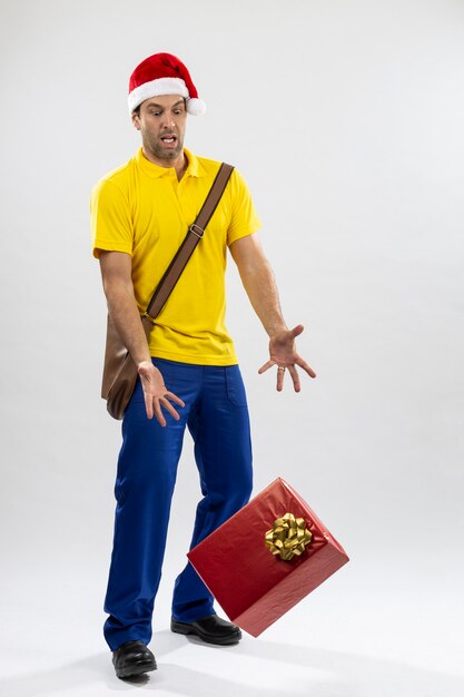 Brazilian mailman dressed as Santa Claus dropping a gift on a white background. copy space.