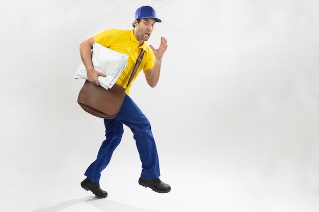 Brazilian mailman running with a package on a white background. copy space.