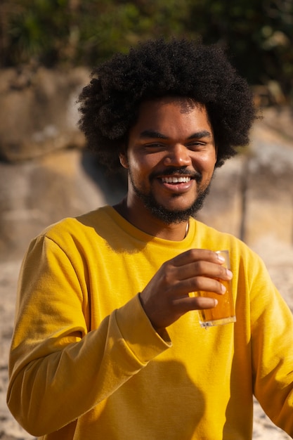 Photo brazilian man having guarana drink outdoors