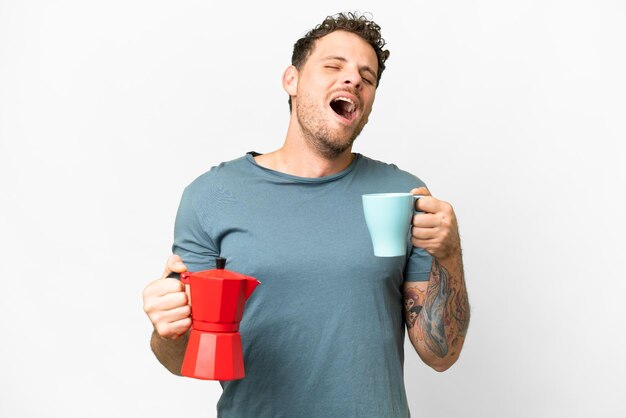 Brazilian man holding coffee pot over isolated white background