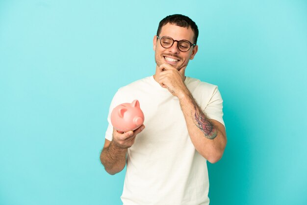 Brazilian man holding a piggybank 