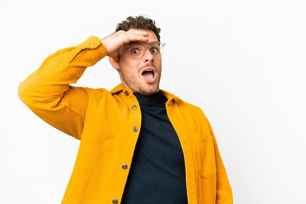 Brazilian man over isolated white background doing surprise gesture while looking to the side