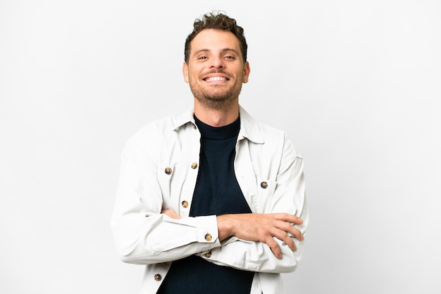 Brazilian man over isolated white background keeping the arms crossed in frontal position