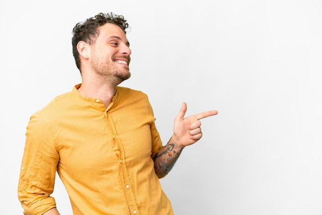 Brazilian man over isolated white background pointing finger to the side and presenting a product