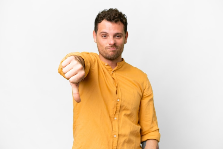 Photo brazilian man over isolated white background showing thumb down with negative expression