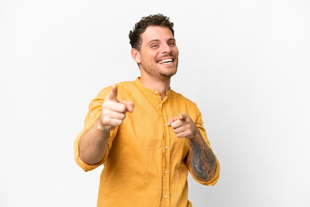 Brazilian man over isolated white background surprised and pointing front