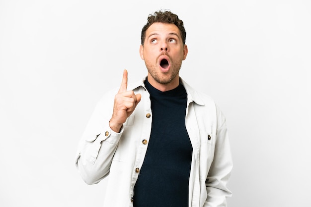 Brazilian man over isolated white background thinking an idea pointing the finger up