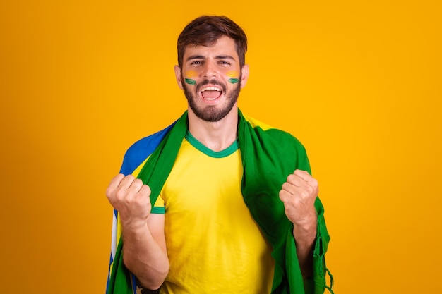 Brazilian man latin american cheering for brazil in the world cup 2022 fan brunette celebrating vibrating happy screaming goal handsome