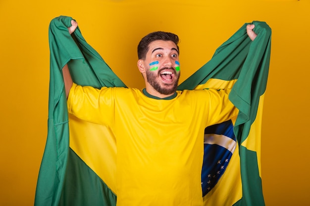 Brazilian man latin american cheering for brazil in world cup\
2022 patriot nationalist vibrating brazil flag cheering and jumping\
symbol of happiness joy and celebration with brazil flag