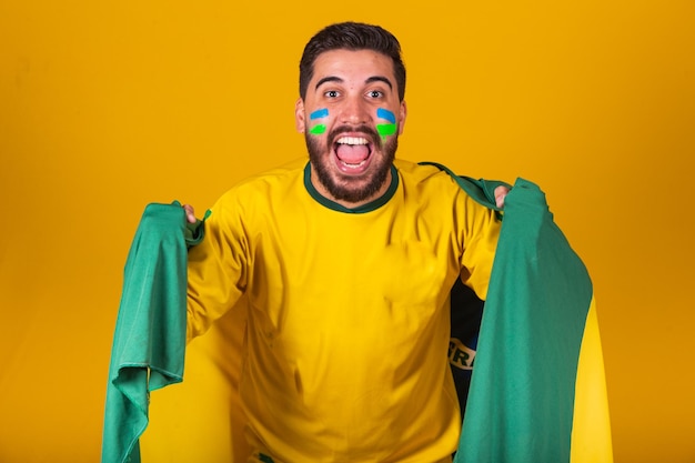 Brazilian man latin american cheering for brazil in world cup\
2022 patriot nationalist vibrating brazil flag cheering and jumping\
symbol of happiness joy and celebration with brazil flag