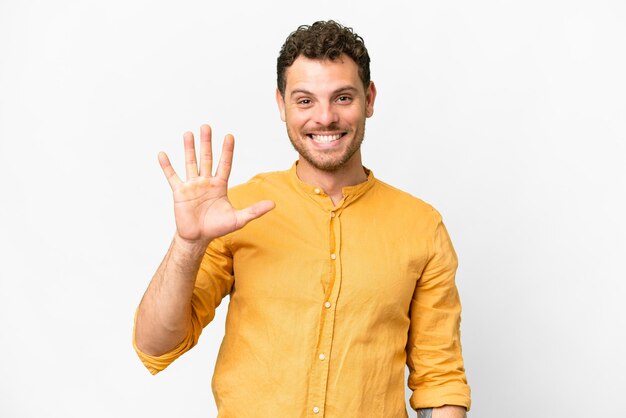Фото Бразильский мужчина на изолированном белом фоне считает пять пальцами