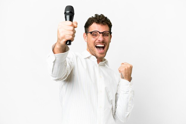 Brazilian man picking up a microphone over isolated white background