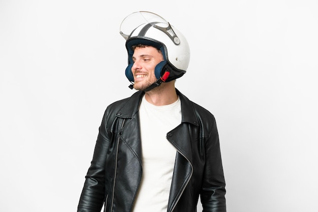 Foto uomo brasiliano con un casco da motociclista su sfondo bianco isolato guardando il lato