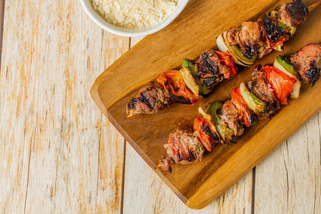 brazilian meat skewer known as 'espetinho de carne' over wooden table