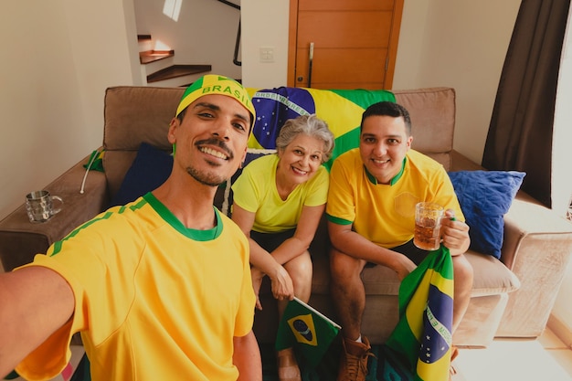 ブラジルの混血家族 サッカーの試合を見ながら居間でカップを祝う カップの試合を見ながら自撮り写真を撮る家族