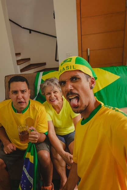 ブラジルの混血家族 サッカーの試合を見ながら居間でカップを祝う カップの試合を見ながら自撮り写真を撮る家族