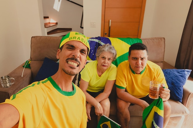 Brazilian Mixed Race Family Celebrating the cup in the living room watching football game Family taking selfie photo while watching cup game