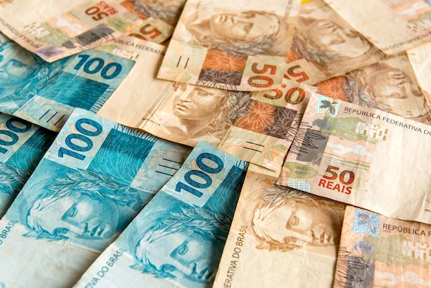 Фонд текстуры бразильских денег Банкноты номиналом 50 бразильских реалов и банкноты номиналом 100 бразильских реалов