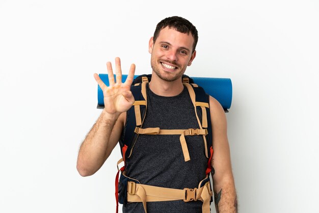 Uomo brasiliano alpinista con un grande zaino su sfondo bianco isolato felice e contando quattro con le dita