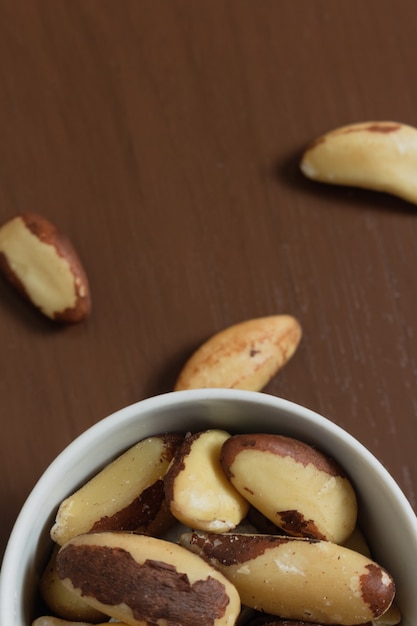 Brazilian nuts in a bowl on a wooden table.